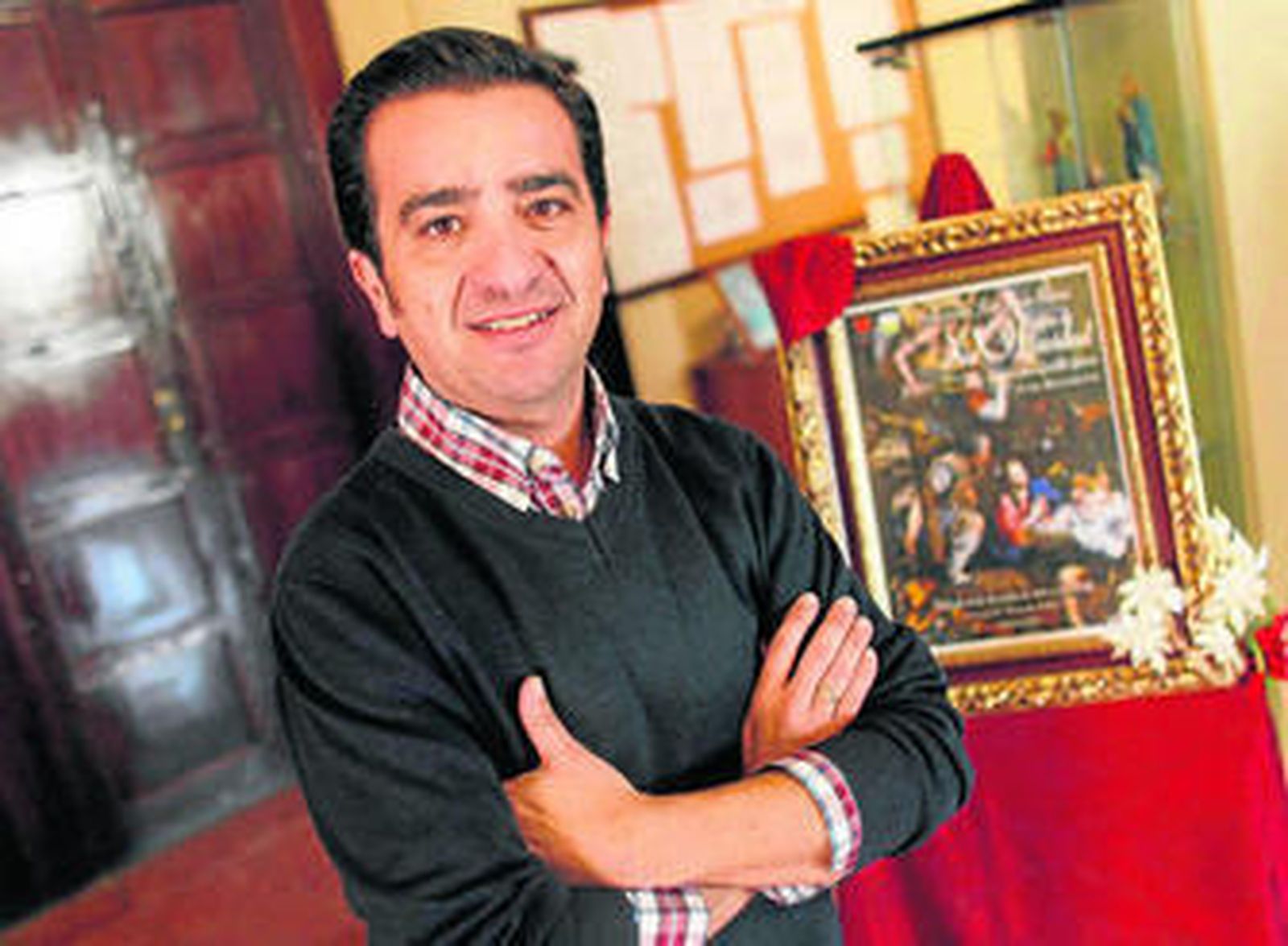 Juan Carlos Gordillo posa a la entrada de la capilla salesiana junto al cartel anunciador del pregón, ayer.