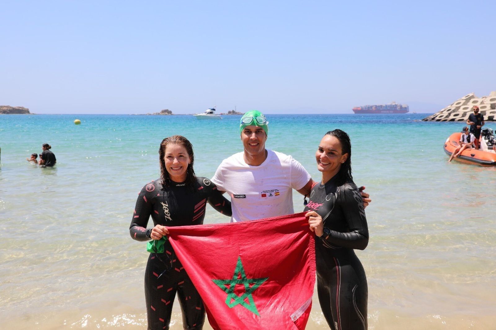Los tres nadadores, con la bandera de Marruecos.