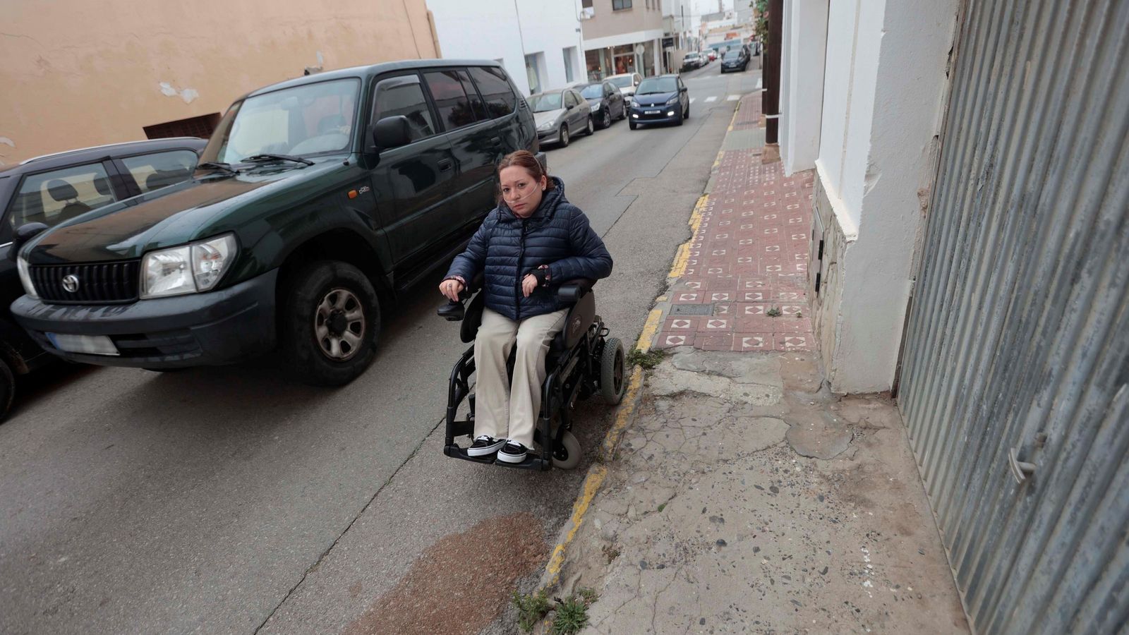 Un coche pasa a escasos centímetros de la silla de ruedas de María Amor, en la calle Pío XII.