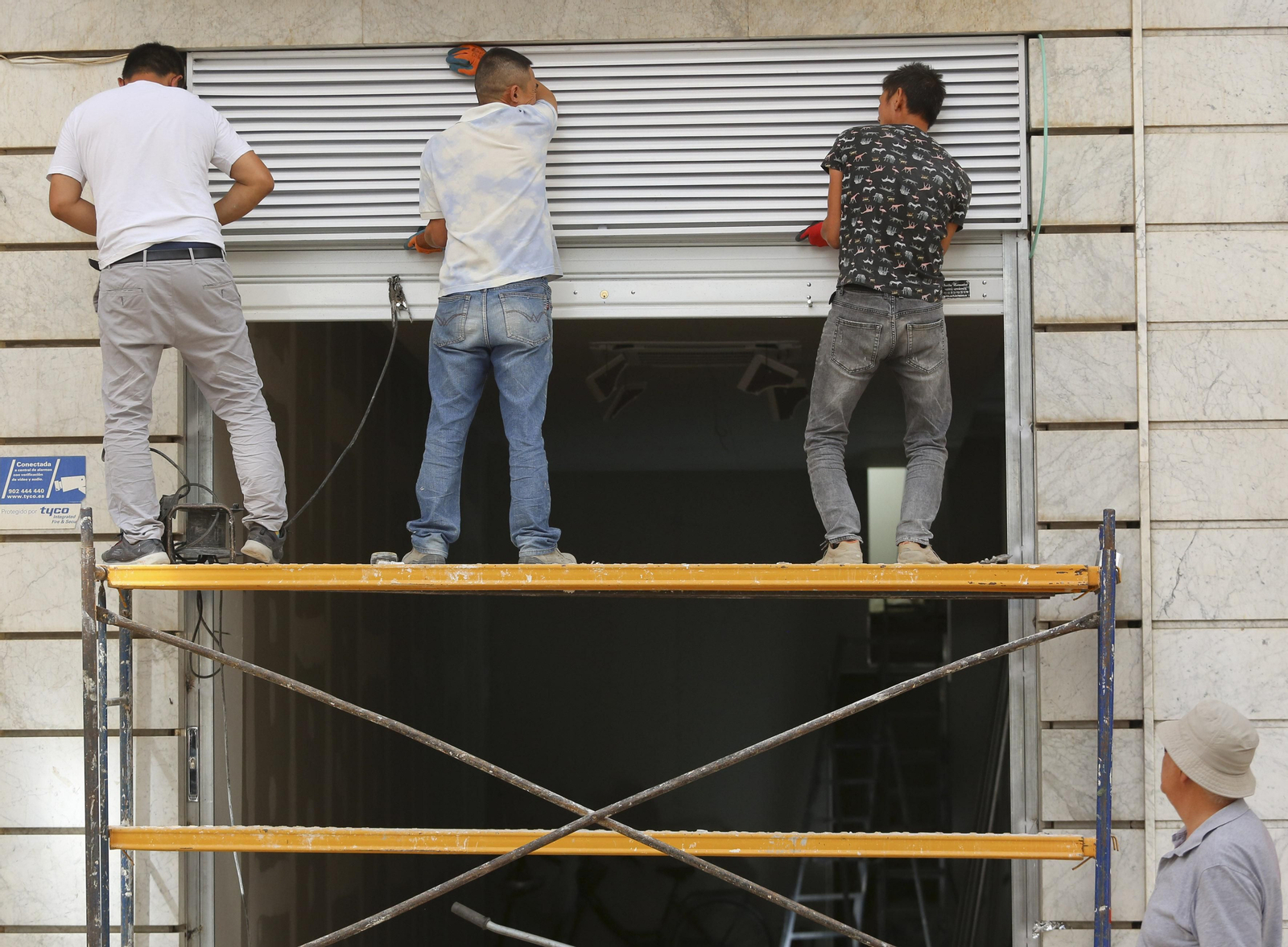 Trabajadores sobre un andamio.