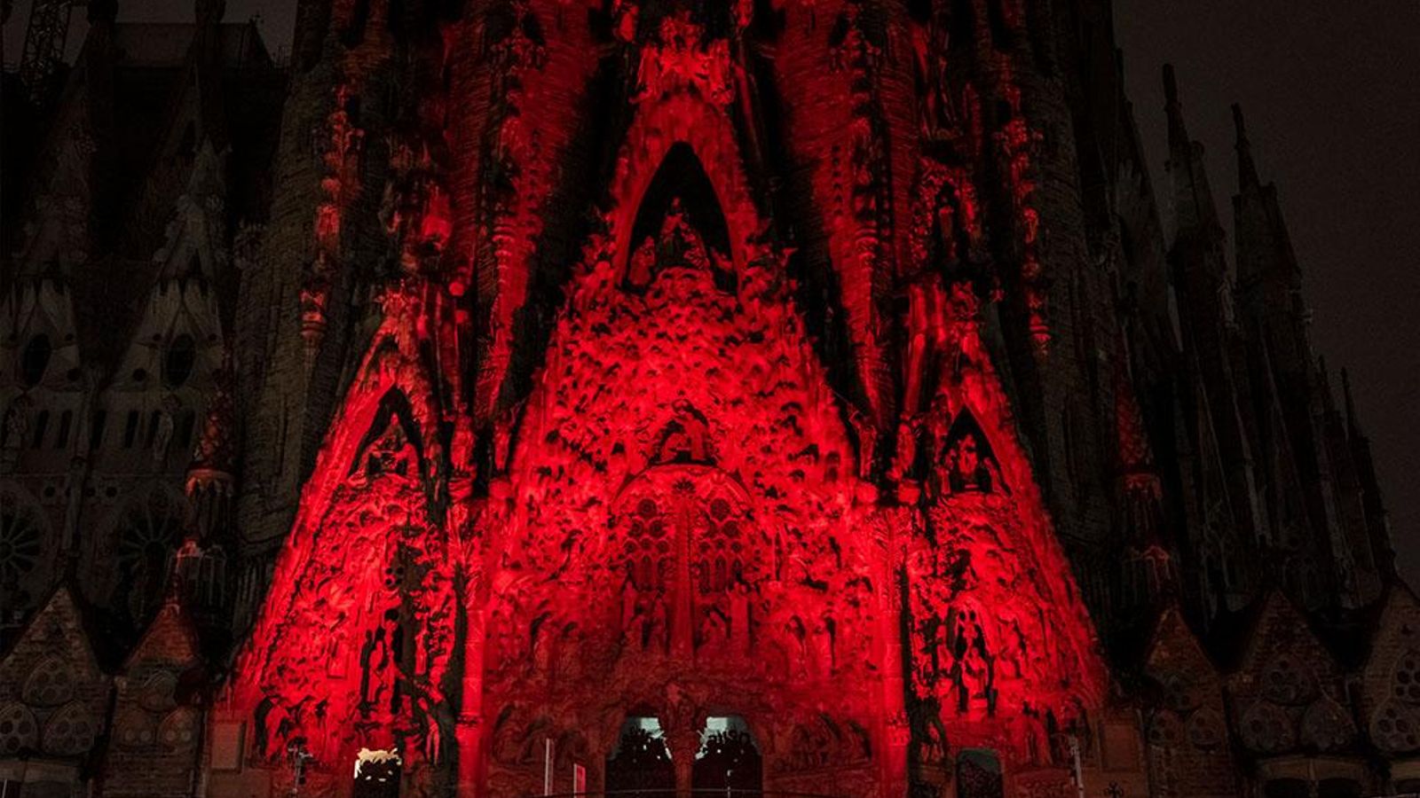 Sagrada Familia iluminada de color rojo.