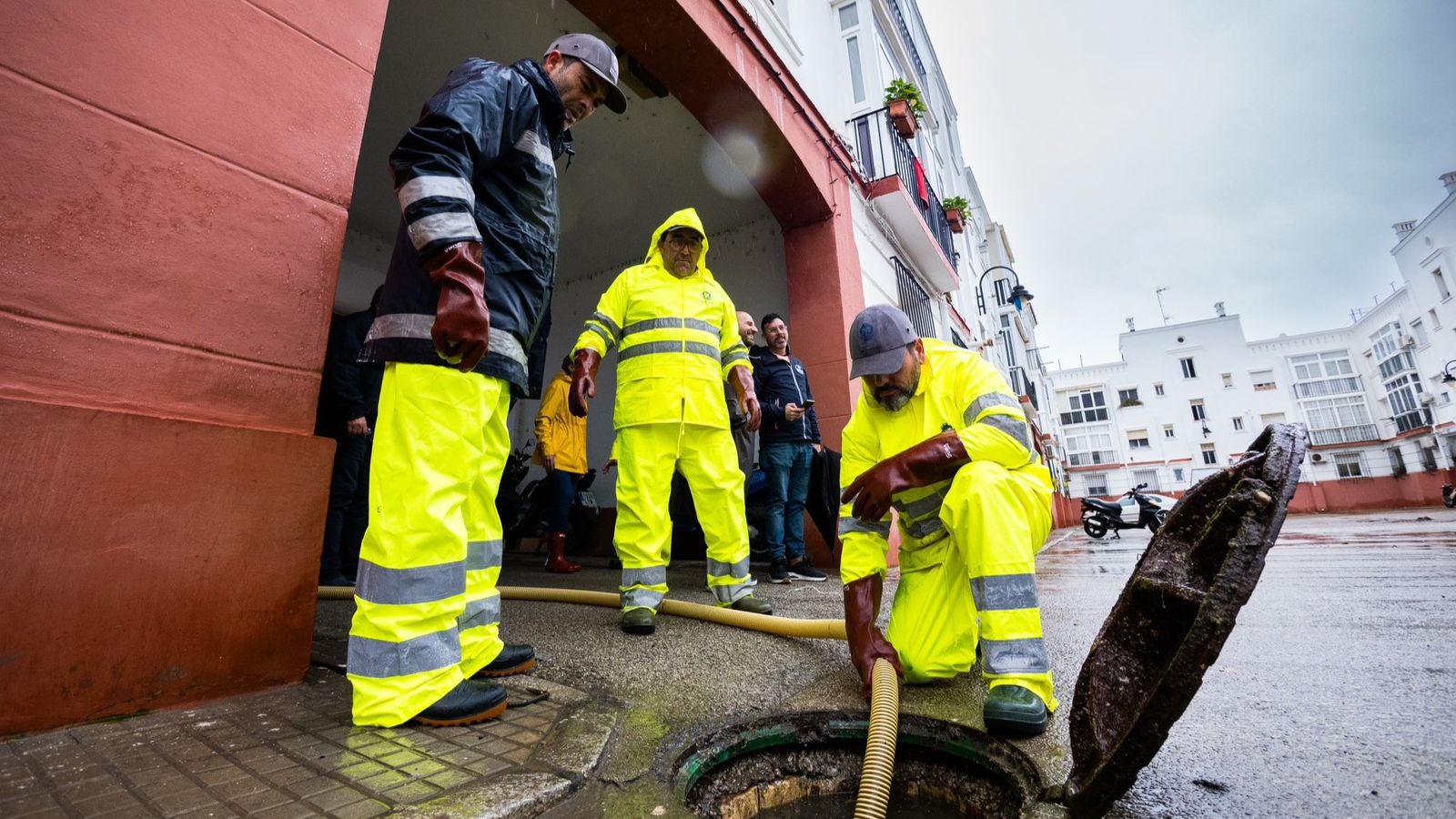 Operarios de alcantarillado, en uno de los patios de la barriada Bazán, en San Fernando, durante el pasado fin de semana