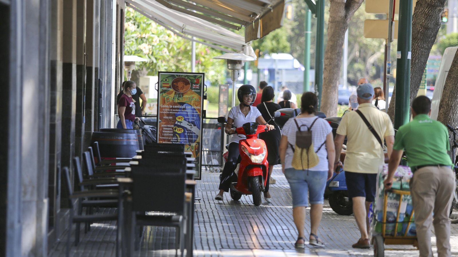 Transeúntes, repartidores y algunas terrazas en la acera norte.