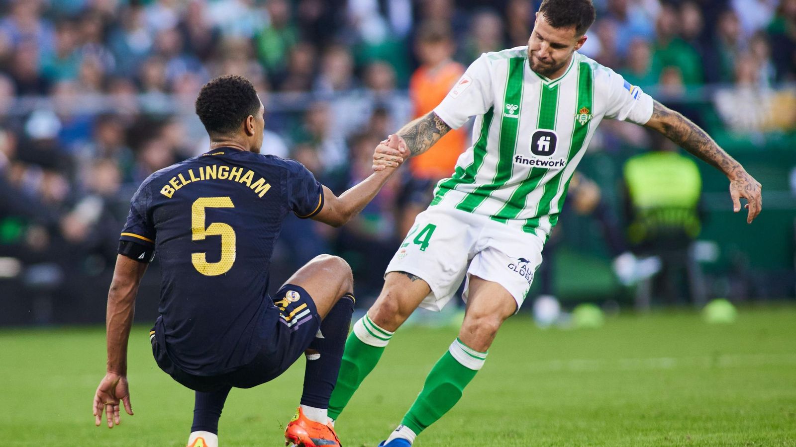 Aitor Ruibal ayuda a levantarse a Bellingham.