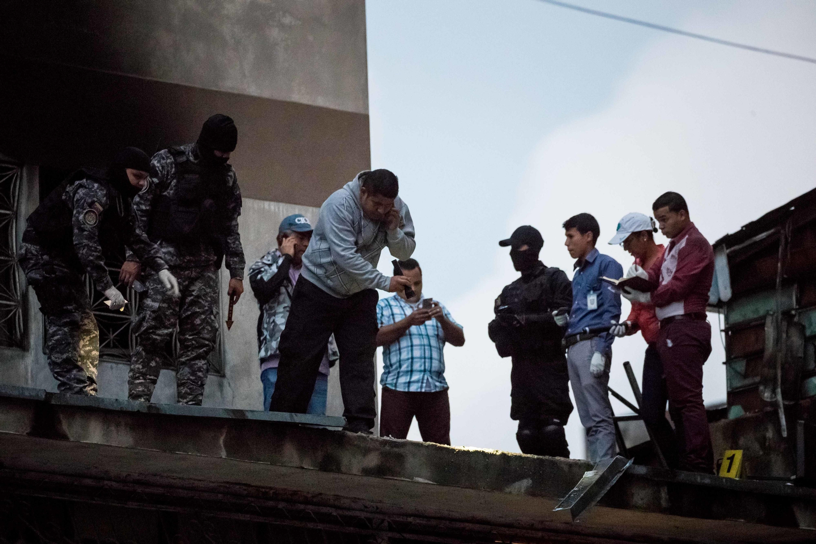 Varios efectivos de seguridad venezolanos toman pruebas en un edificio de Caracas tras el ataque del sábado.