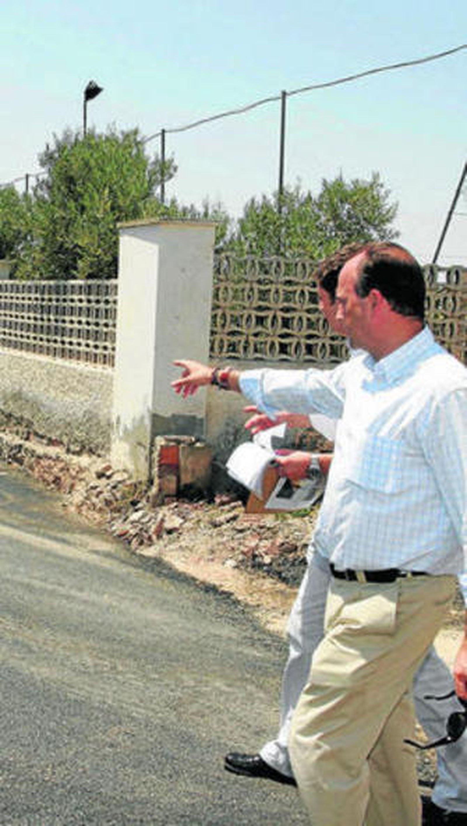 El alcalde de la capital señala hacia uno de los caminos que serán arreglados.