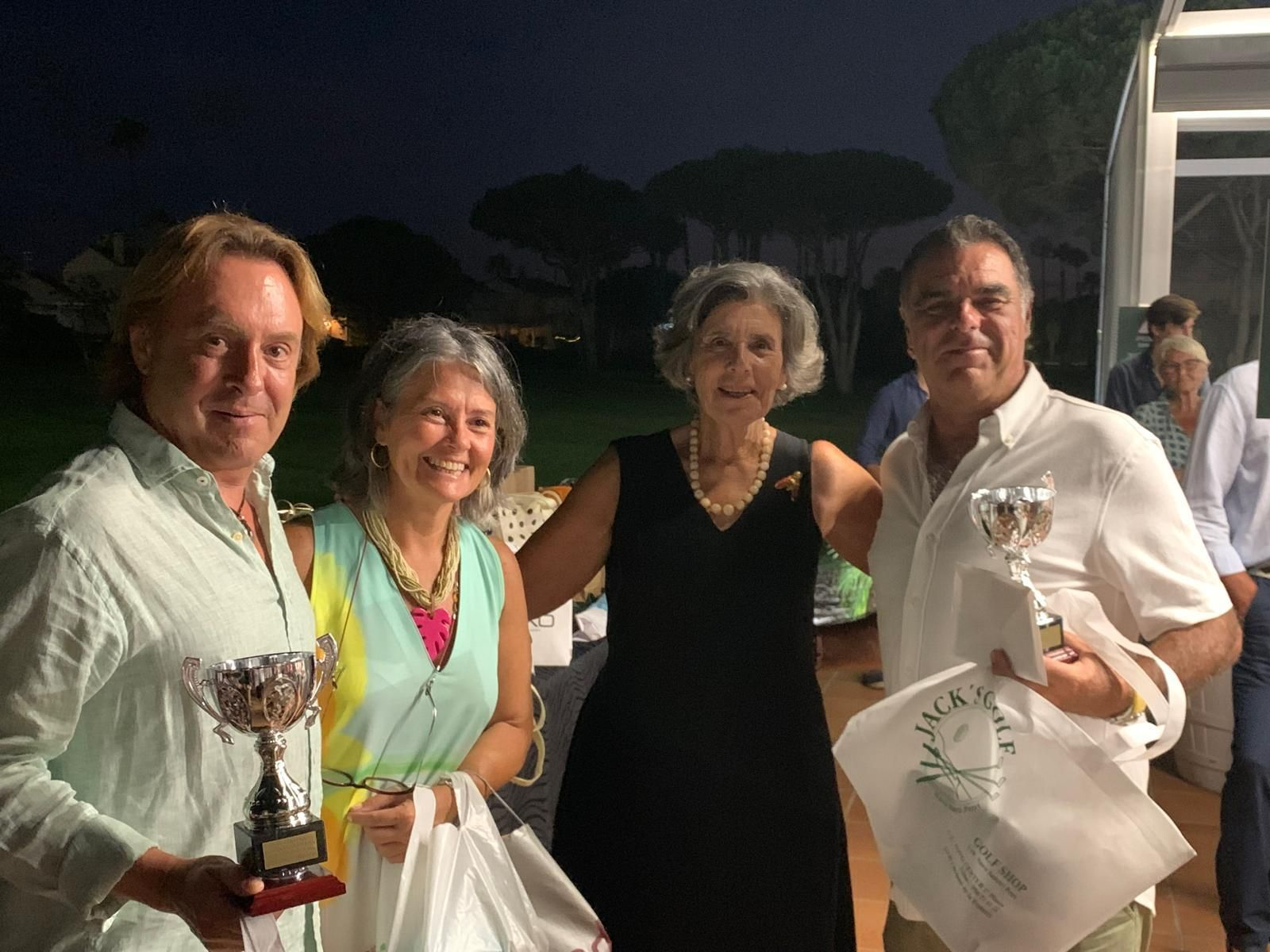 La pareja ganadora muestra sus trofeos, junto a miembros de la organización.