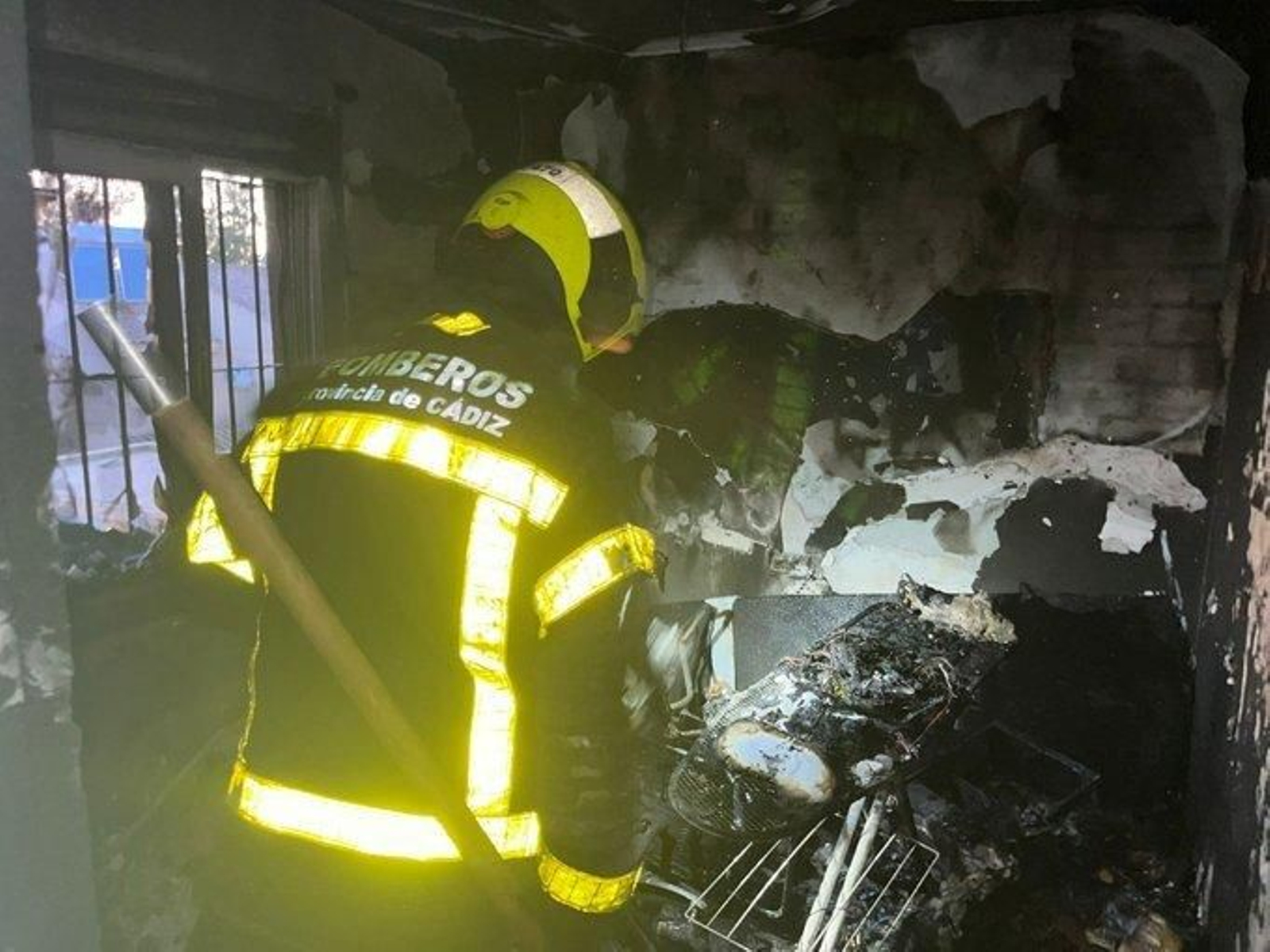 Uno de los bomberos en la vivienda unifamiliar en la que se registró el incendio en Jerez