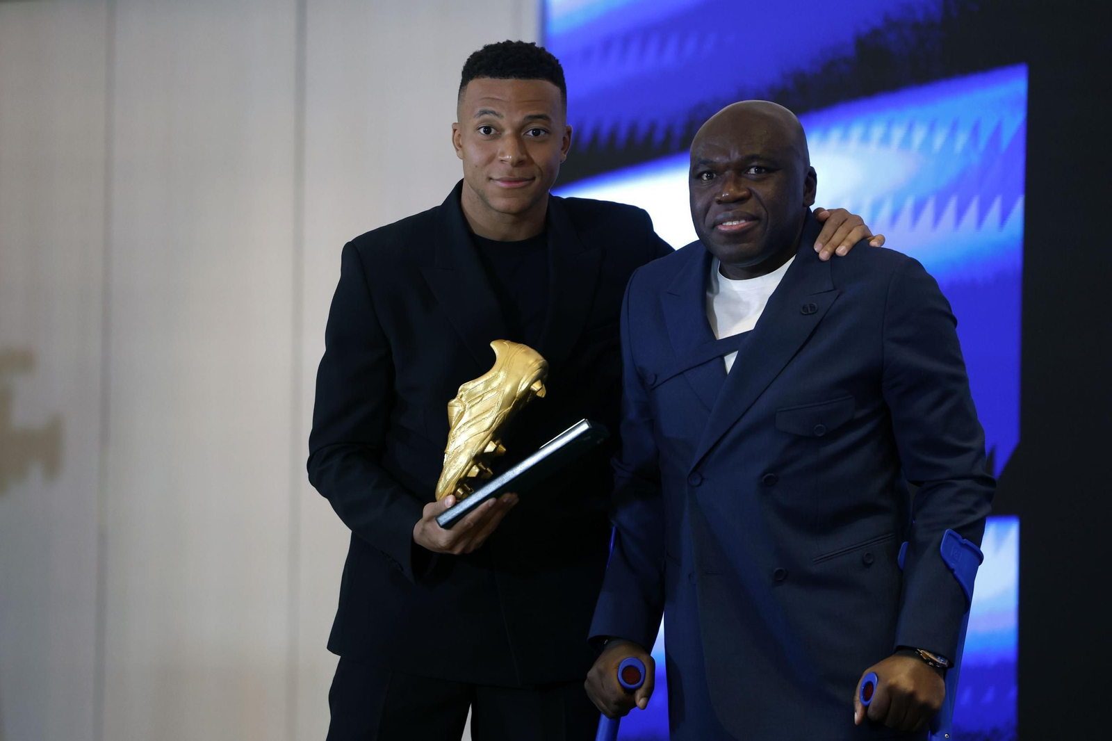 El delantero francés del Real Madrid Kylian Mbappé recibe junto a su padre Wilfried la Bota de Oro.