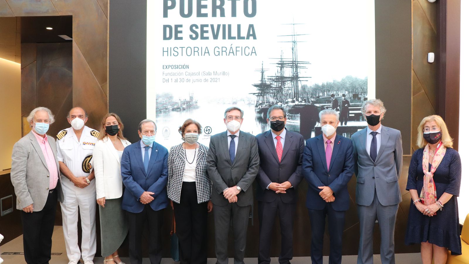 Los presidentes del Puerto de Sevilla y de Puertos del Estado flanquean a Antonio Pulido, junto a otras autoridades ante el cartel de la exposición.