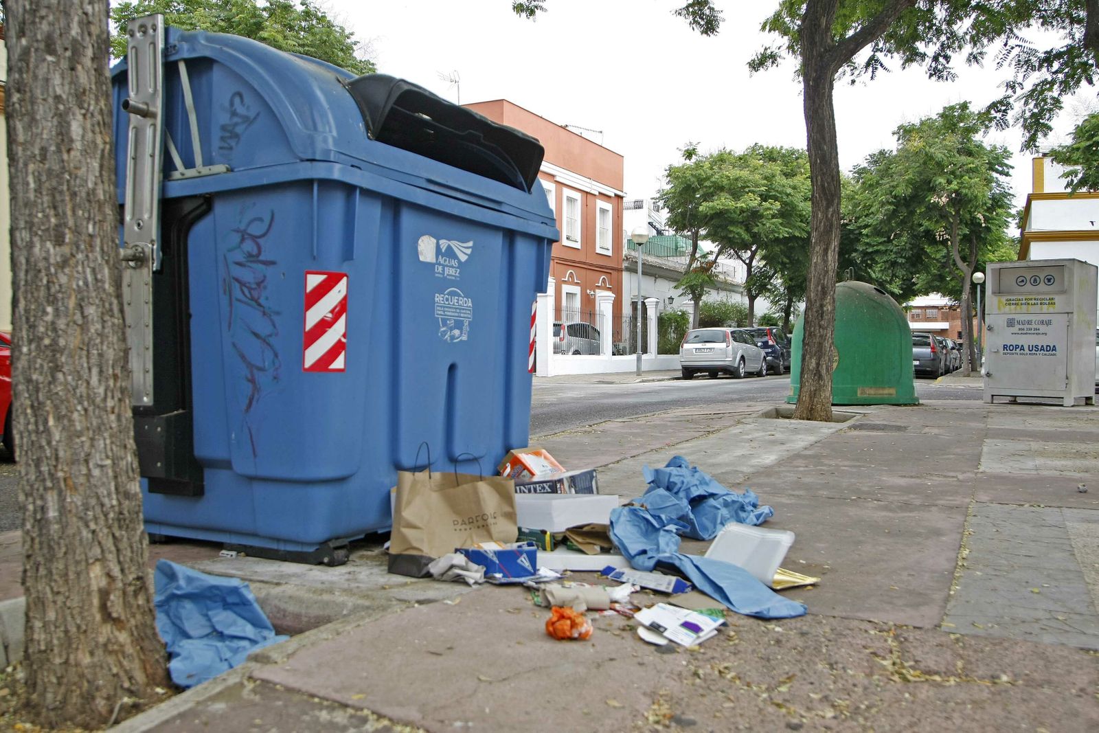 Restos de papel y cartón fuera de un contenedor en la Barriada España.