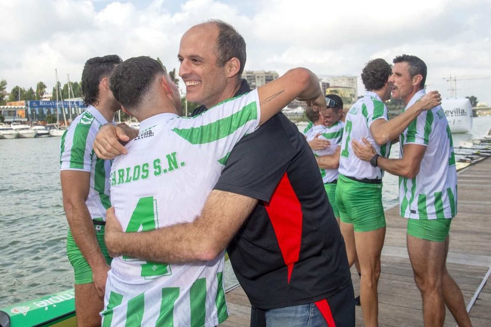 Ignacio Muñoz se abraza con un tripulante del Betis tras la última regata.