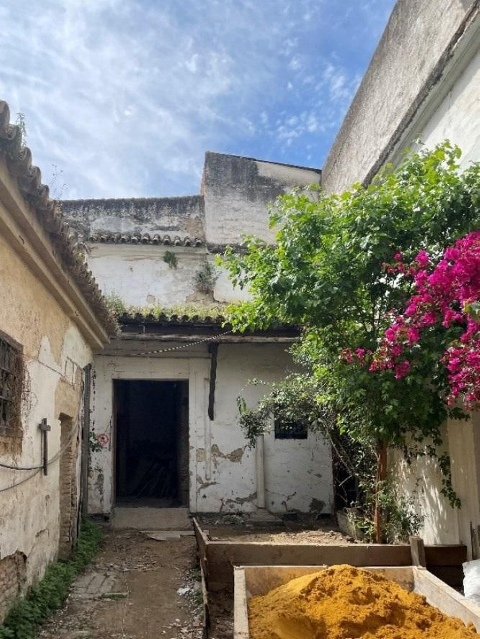 Vista frontal de la puerta reglar y patio de acceso.