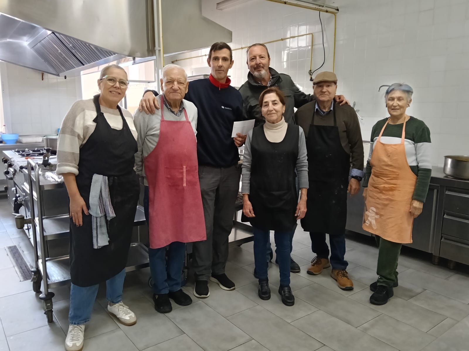 El vicedirector del centro, entregando a la Fundación Hogar San Juan el donativo en una foto junto a sus voluntarios.