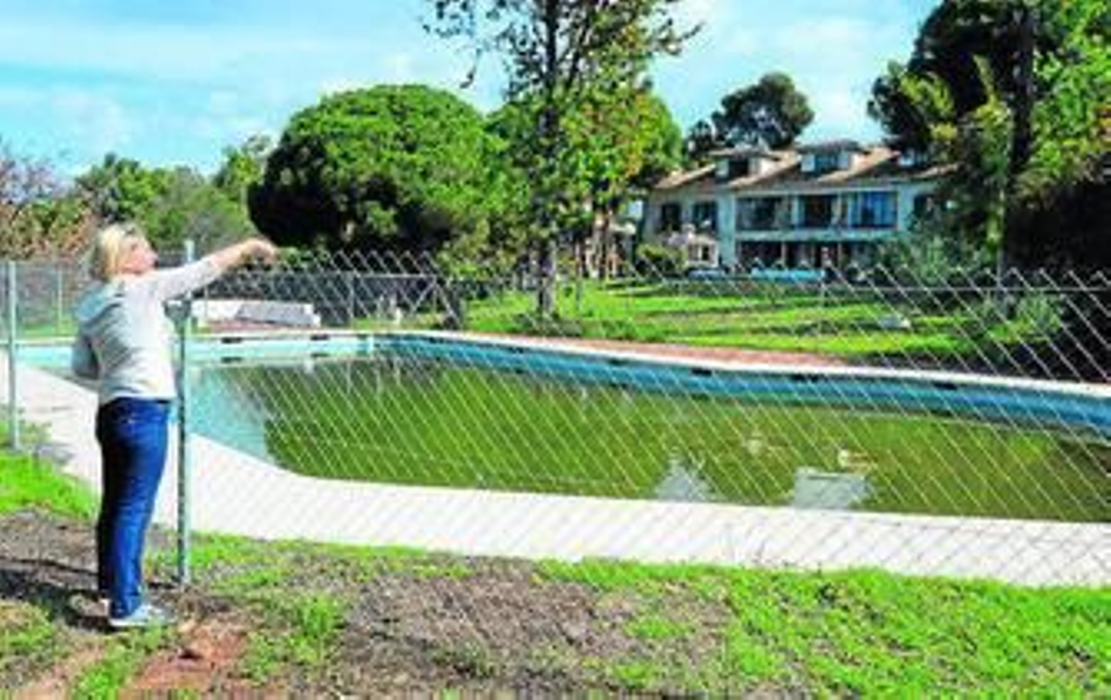 Una vecina señala el estado en el que se encuentra la piscina.