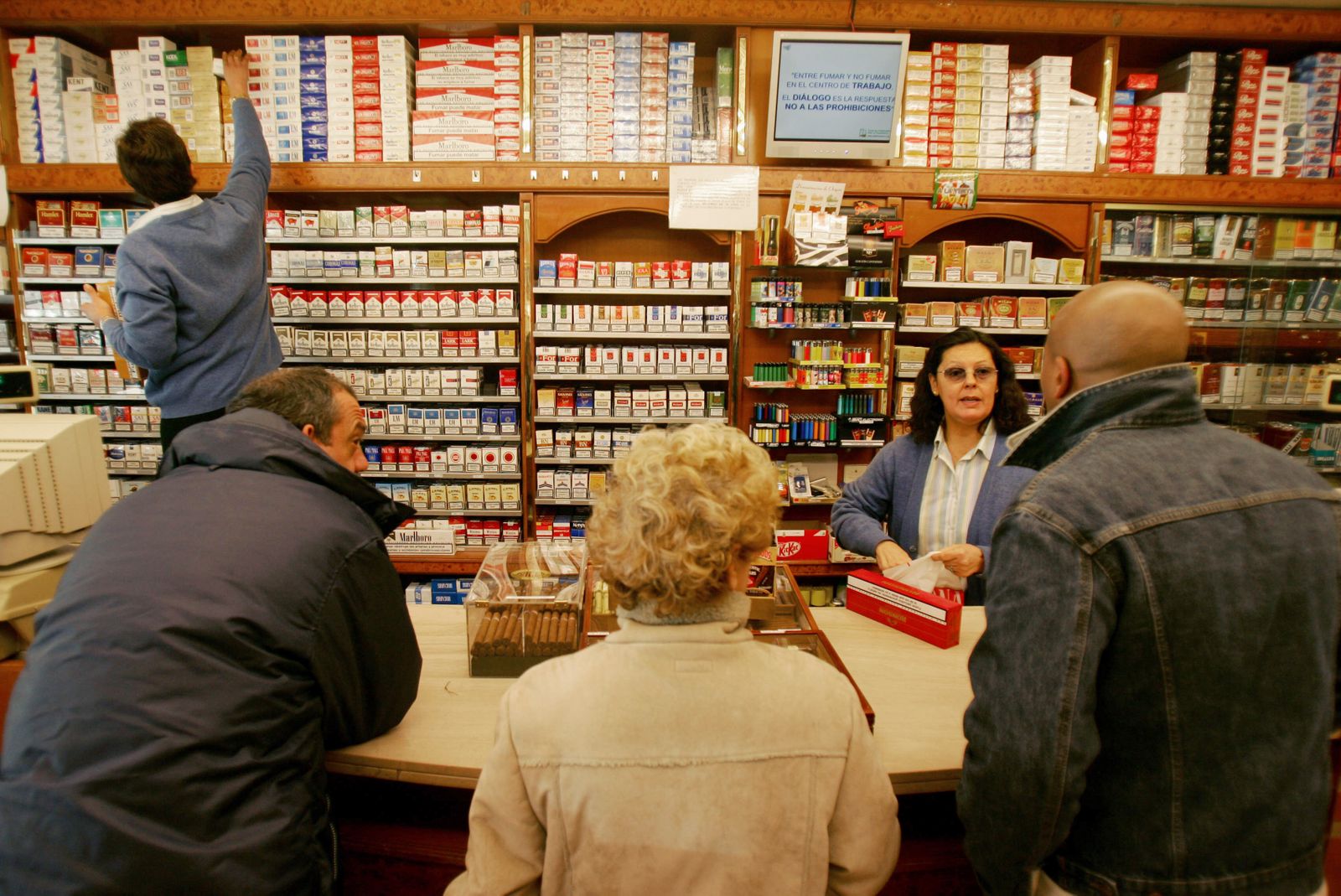 Varias personas compran tabaco en un estanco.