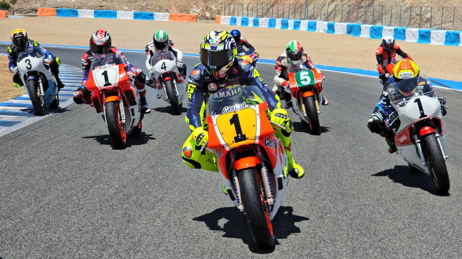 Valentino Rossi pilotando la Yamaha 500 de Lawson flanqueado por otros históricos de Yamaha. Valentino Rossi pilotando la Yamaha 500 de Lawson flanqueado por otros históricos de Yamaha.