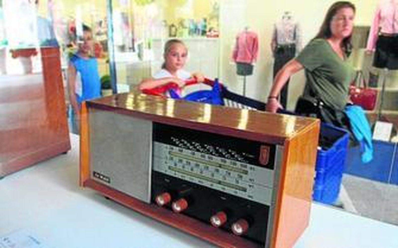 1.3.4. Algunas de las radios de válvulas y transistores que se pueden ver en la exposición, en el centro comercial Holea.                               2. El coleccionista Diego Ramírez; la gerente de Holea, Amelia Romero, y el director comercial de  la emisora Cope en Huelva, Nacho González, en la inauguración  de la muestra.