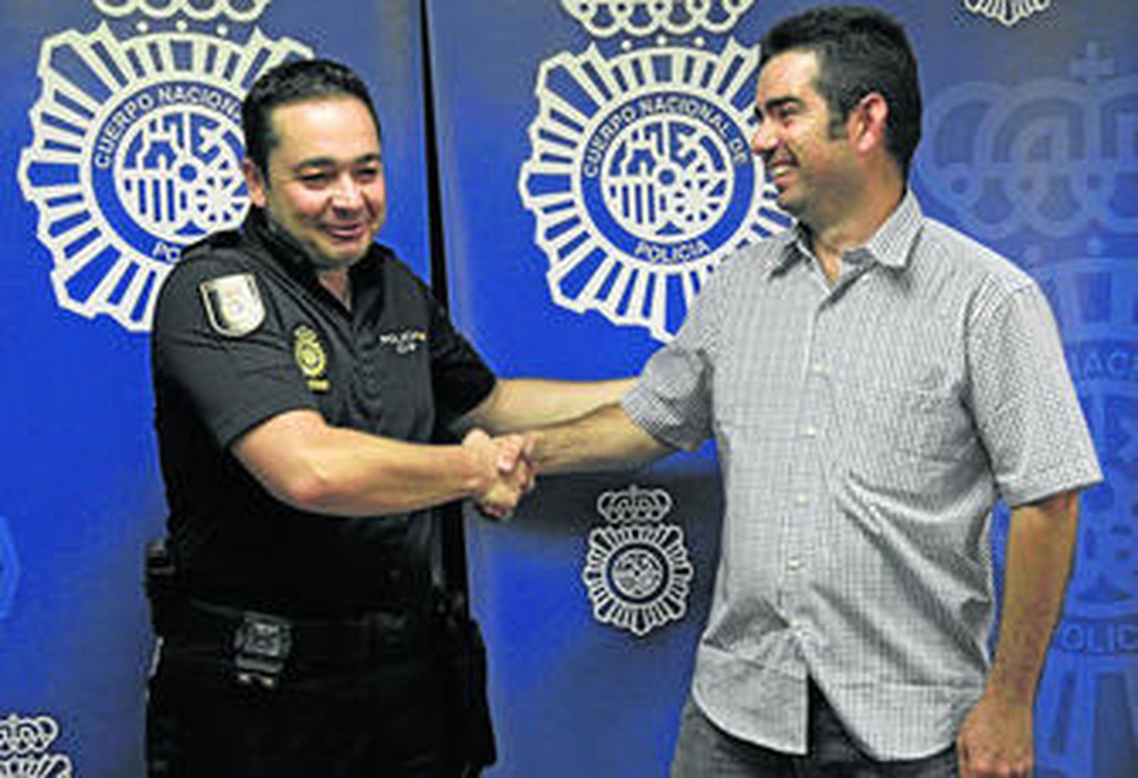 El agente Samuel Herrojo y José Antonio Puentes, padre de la criatura, se dan la mano en la Jefatura de la Policía Nacional.