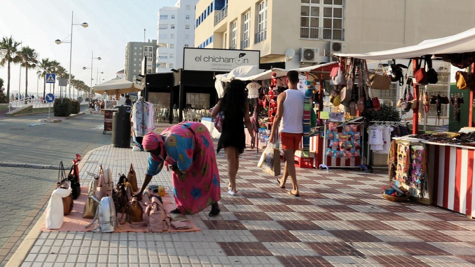 En la imagen una de las vendedoras ambulantes colocando una manta frente a su puesto.