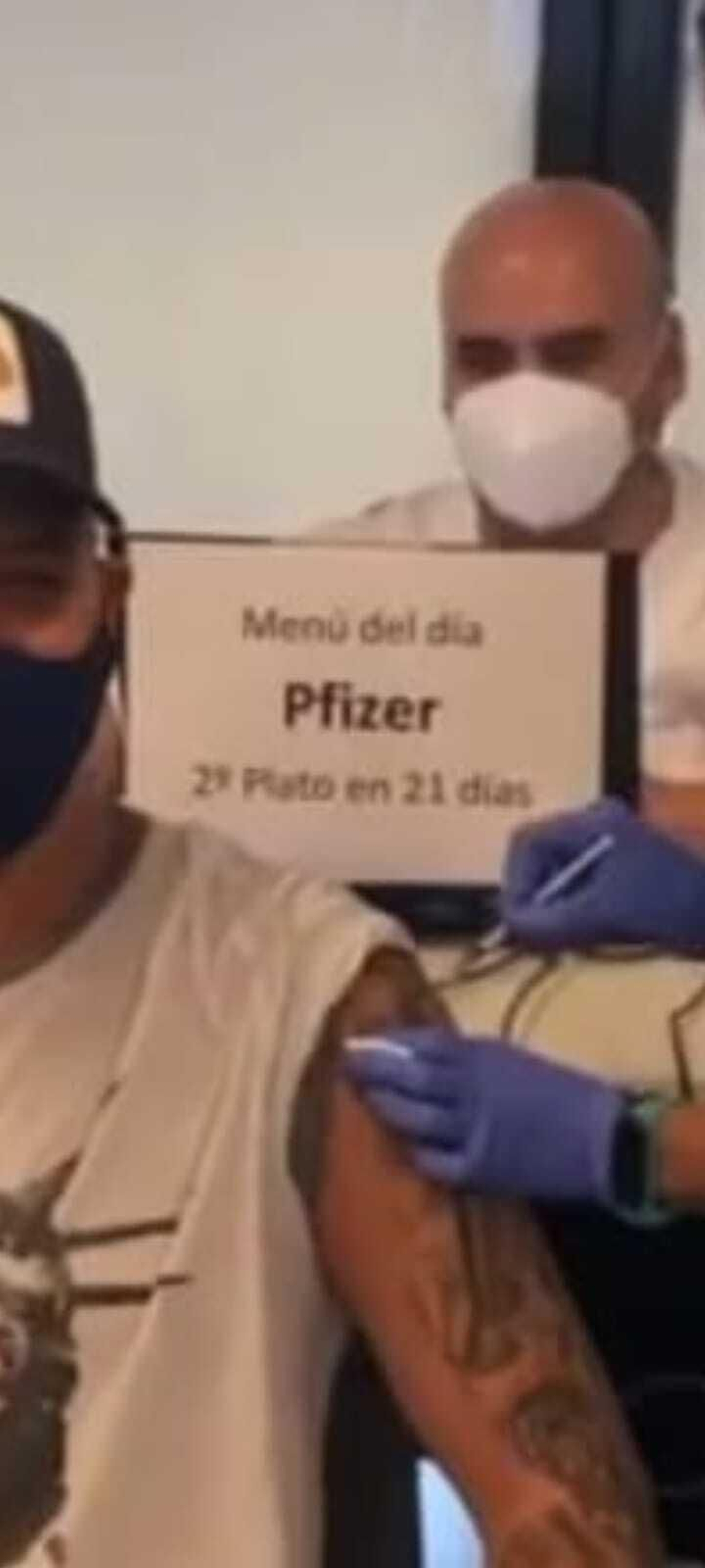 Divertido cartel con el que el enfermero de detrás de Sanz informa de la vacuna que se está poniendo y cuándo hay que ponerse la segunda dosis.
