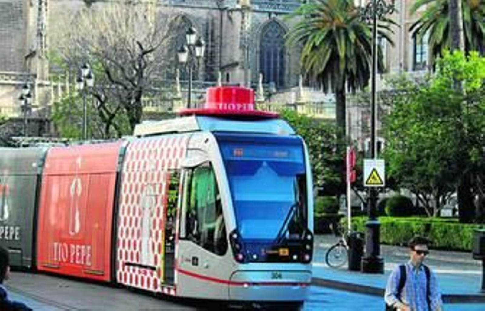 El tranvía con el sombrero de 'Tío Pepe' y el traje de lunares a su paso junto a la catedral de Sevilla.