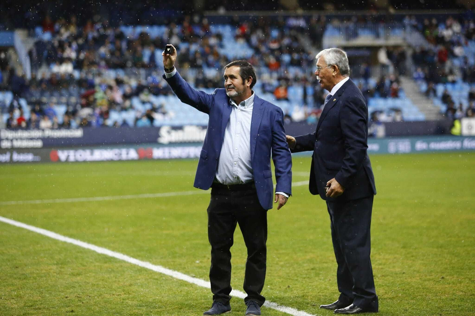 Miguel Zambrana muestra la insignia de oro del Málaga CF junto a Martín Aguilar.