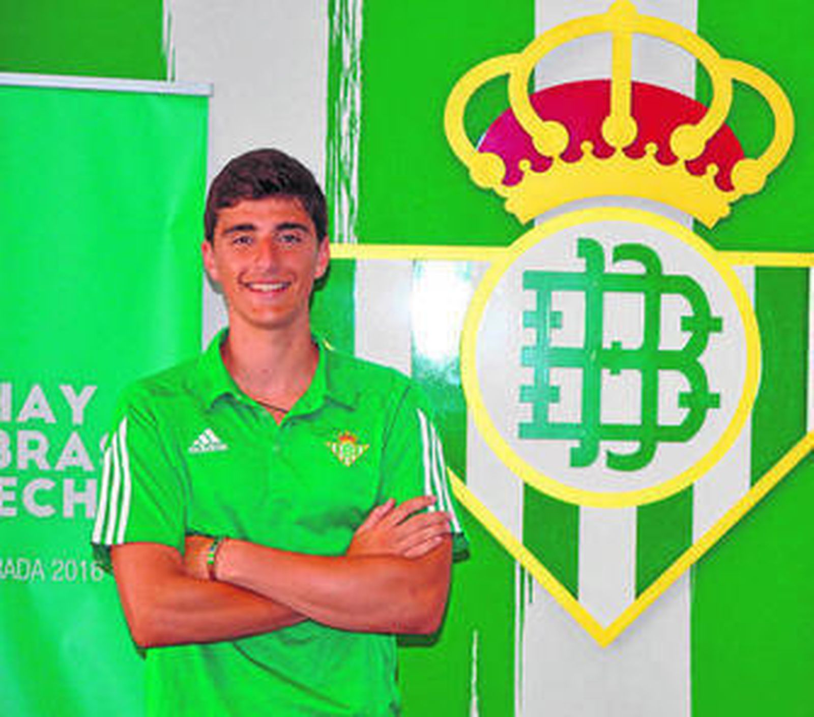 Juan Varela posa delante del escudo del Betis.