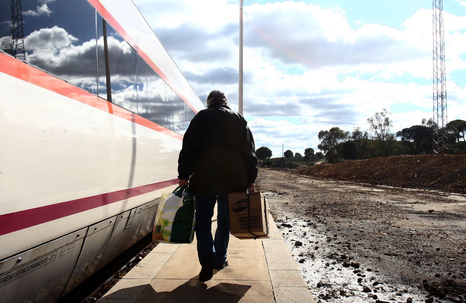 Un viajero se dispone a subir al tren de la línea Huelva-Zafra en una de sus estaciones intermedias.