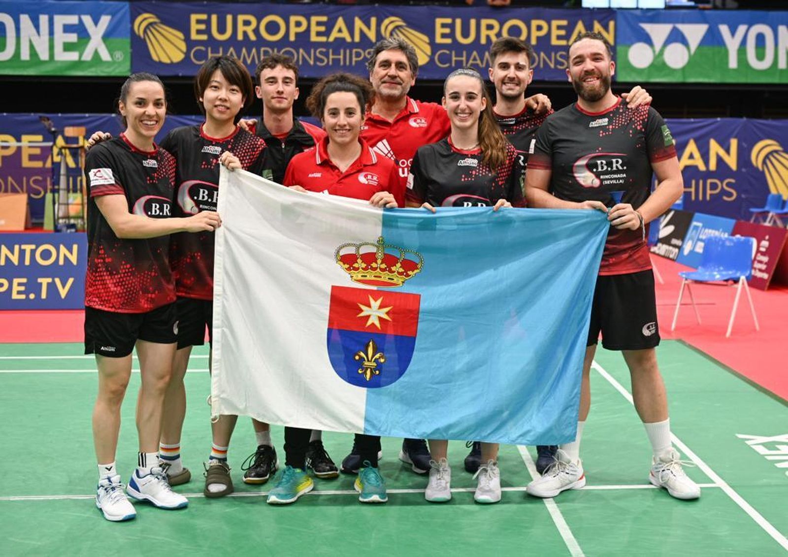 El Rinconada, con la debutante Xu Wei, posa tras el triunfo con la bandera del pueblo.