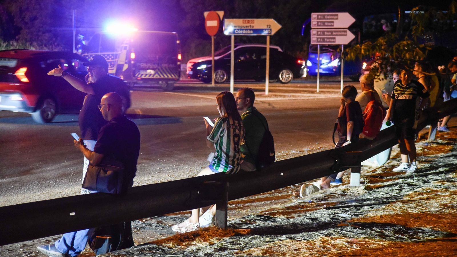 Varios aficionados esperan a ser recogidos en la rotonda en la que comienza la Ronda Supernorte.