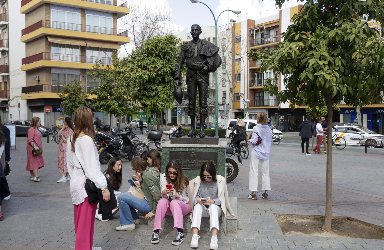 Un grupo de jóvenes en la estatua de Joselito en la Macarena.