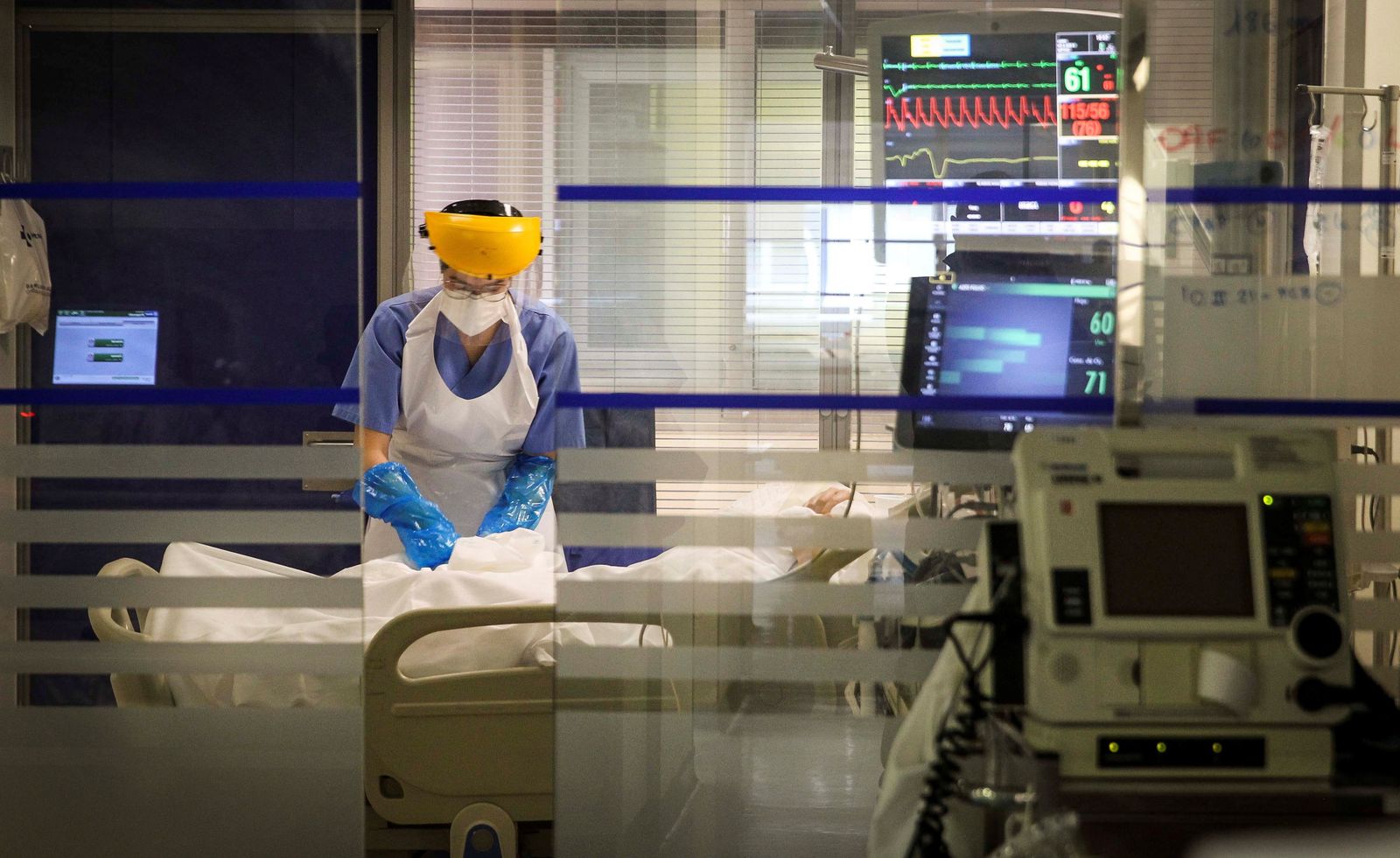 Personal sanitario atiende a un paciente que está en aislamiento en un hospital.