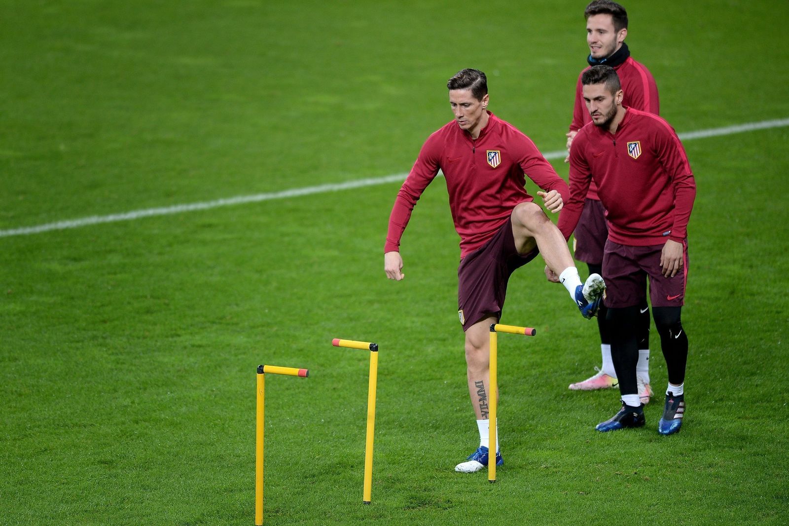 Fernando Torres realiza un ejercicio en el césped del Bayer Leverkusen mientras esperan Koke y Saúl Ñíguez.