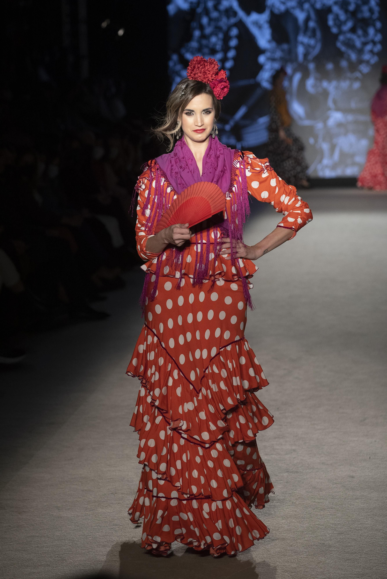 Traje de flamenca rojo combinado con un mantoncillo morado de Rocío Olmedo. Traje de flamenca rojo combinado con un mantoncillo morado de Rocío Olmedo.