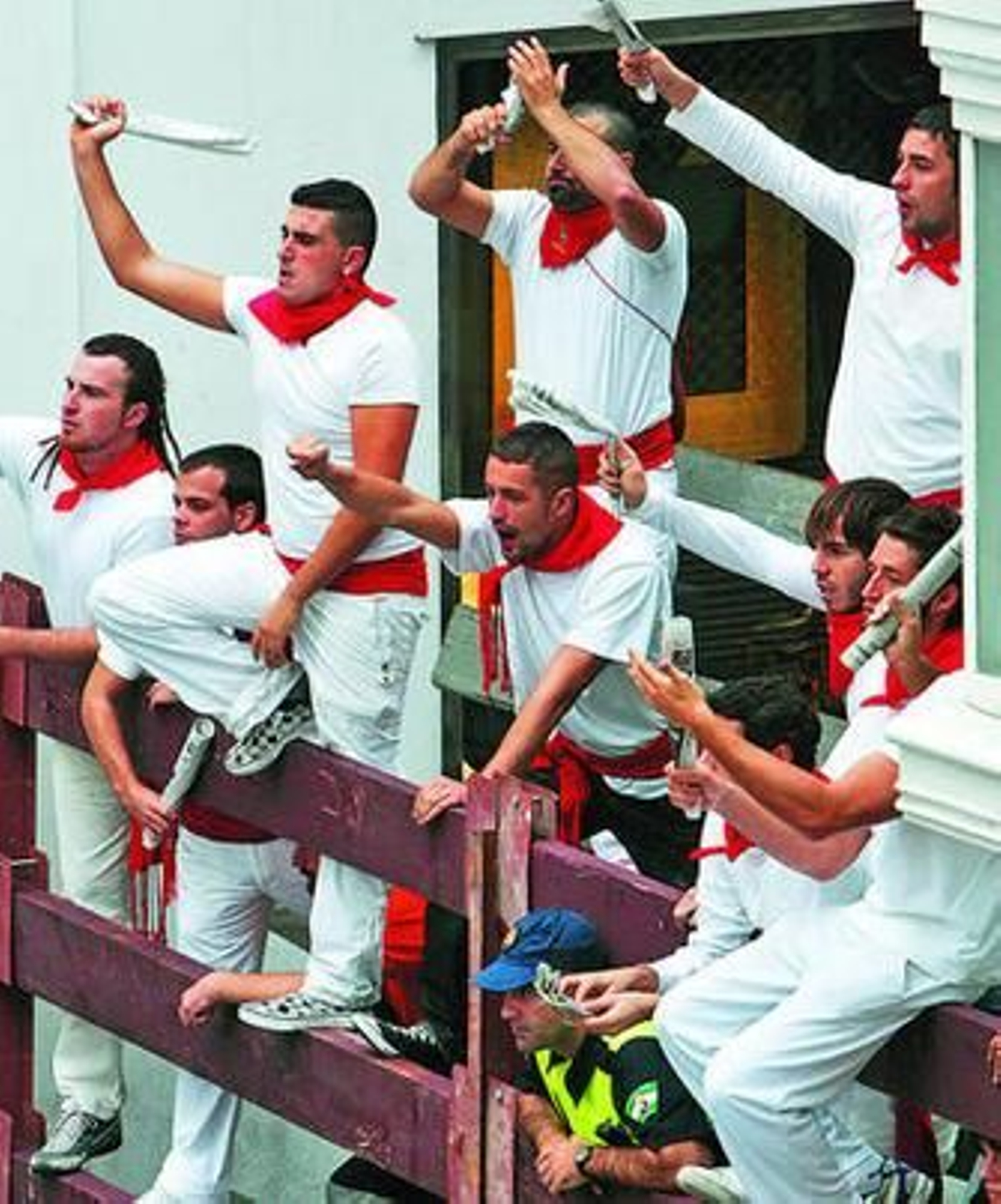 Un grupo de extras subidos a una valla citan a los 'toros' durante un momento del rodaje.