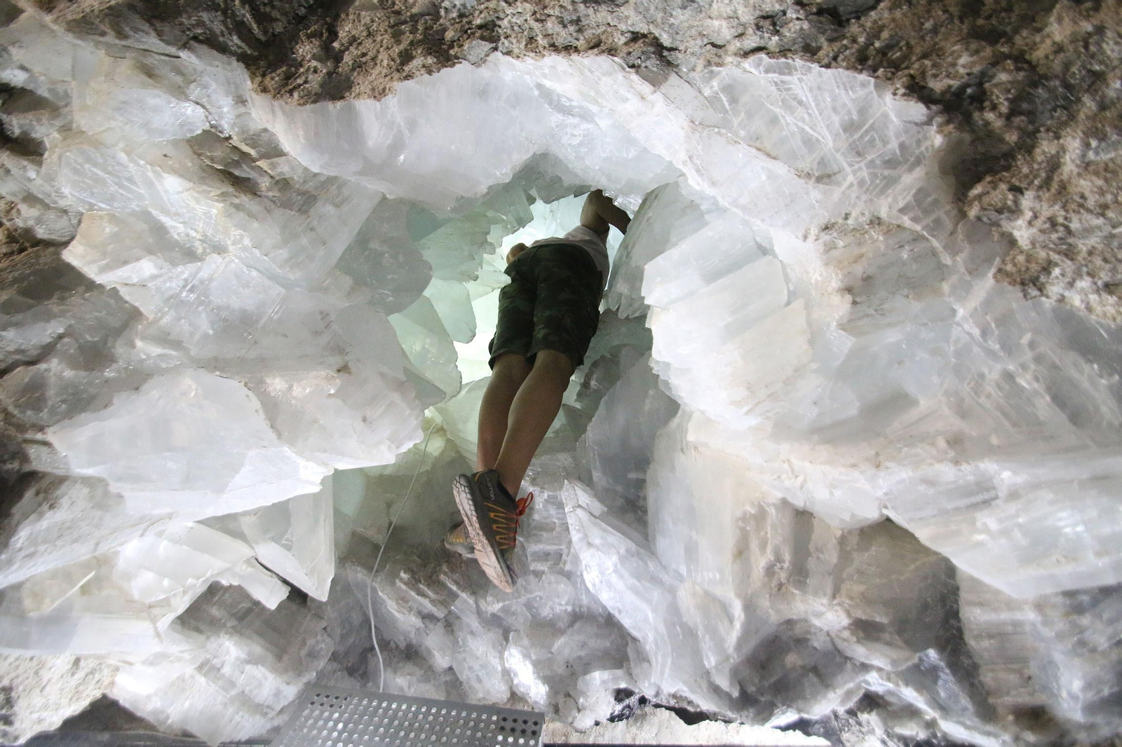 Una persona introduce la cabeza en el interior de la Geoda Gigante de Pulpí.