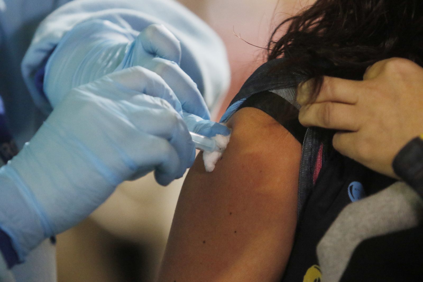 Un sanitario pone la vacuna a una profesora en Córdoba.