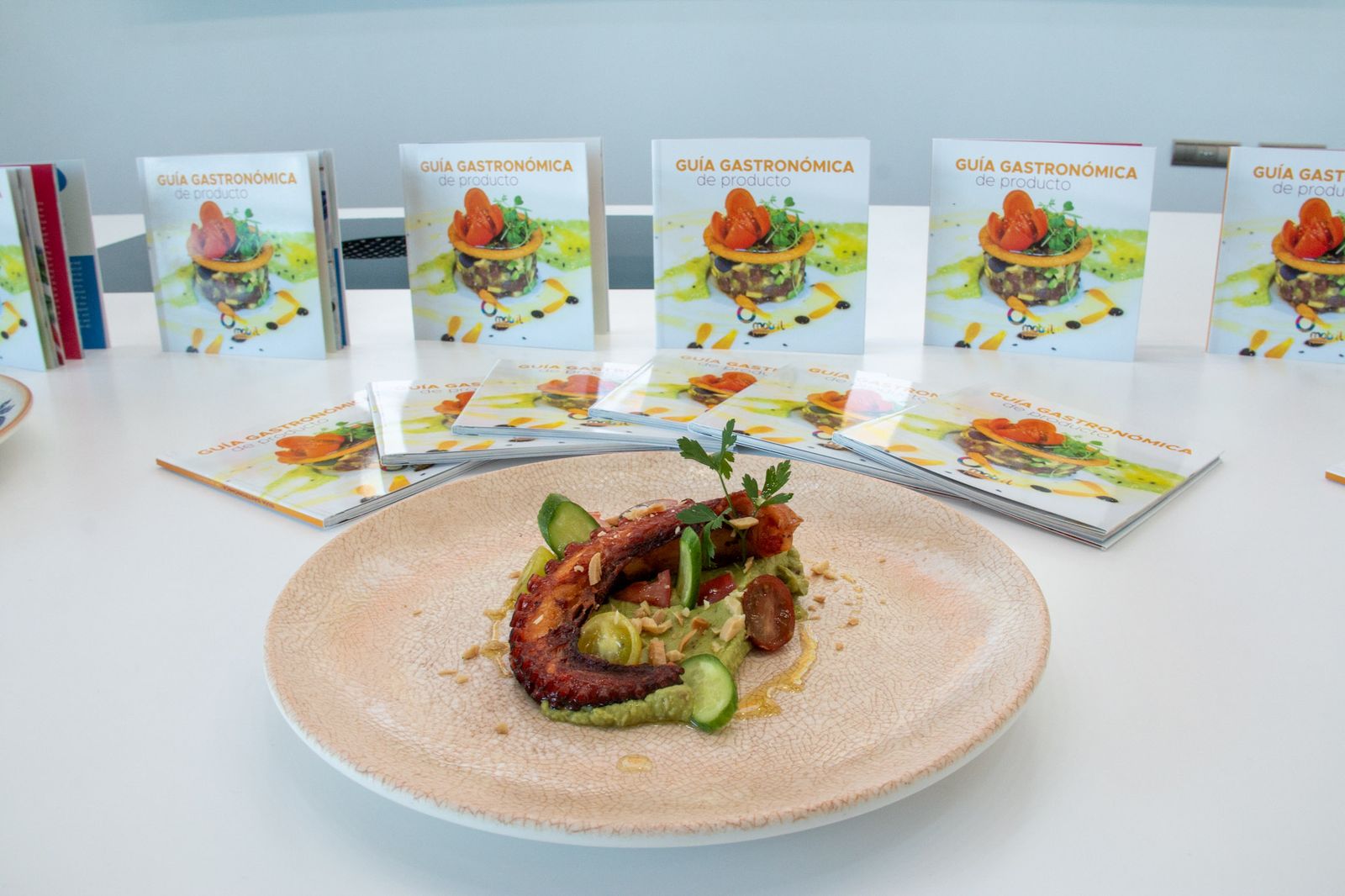 La nueva guía gastronómica de producto junto a un plato elaborado con productos locales