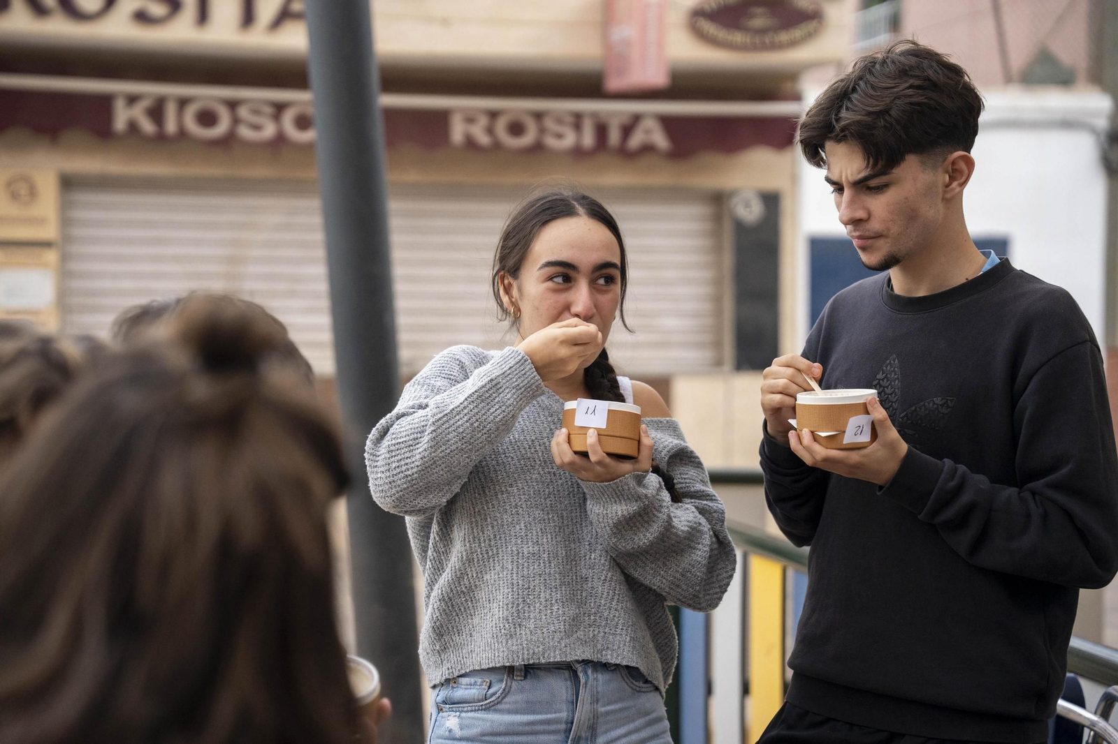 Jóvenes degustando tarta de queso en la inauguración de un nuevo local en El Zapillo.