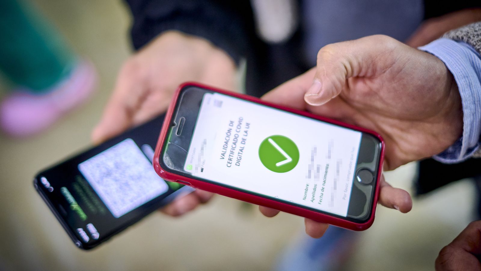 Dos personas muestran su certificado Covid en el móvil.