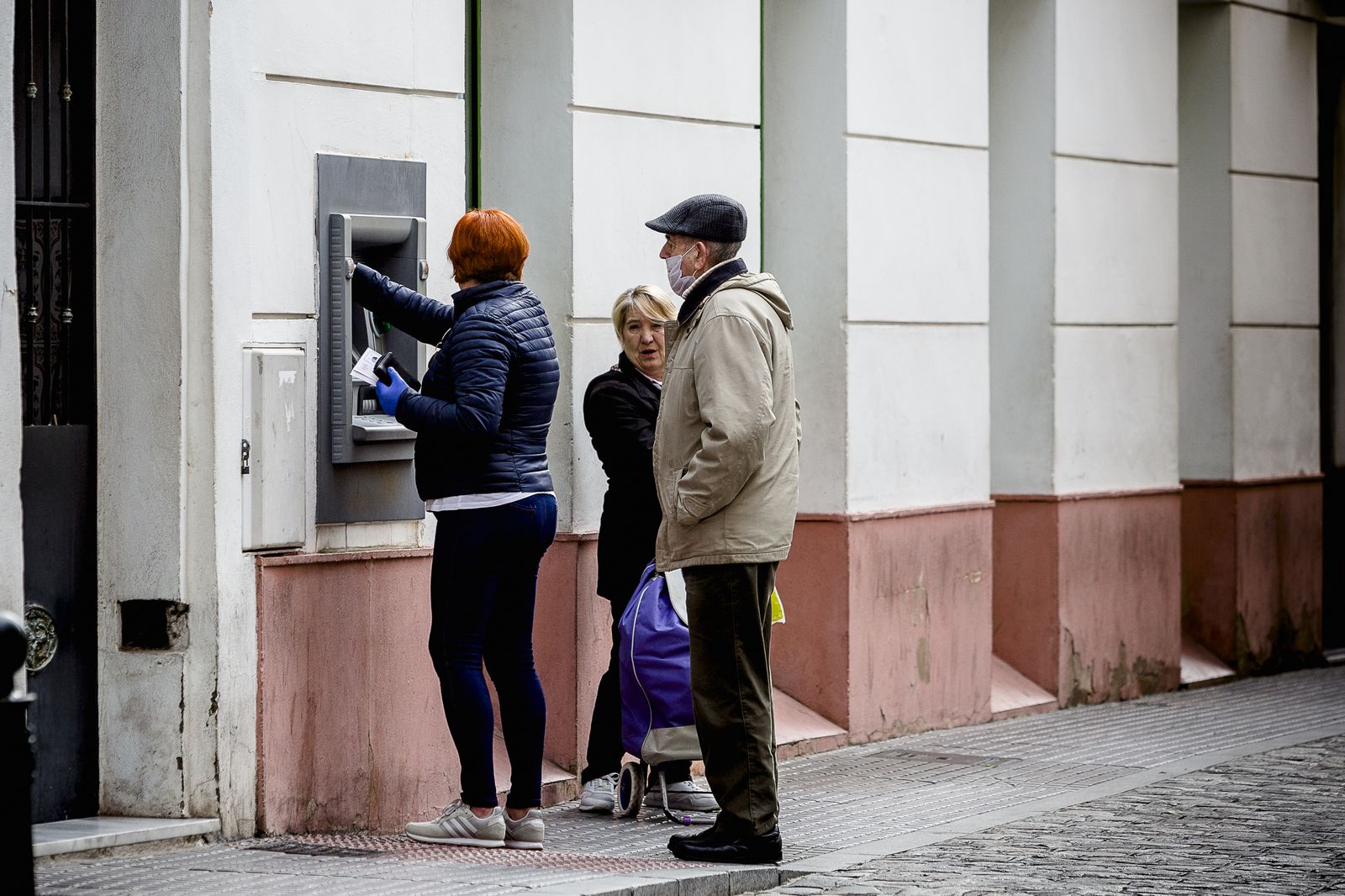 Varios ciudadanos hacen cola en un cajero de la calle de la Rosa