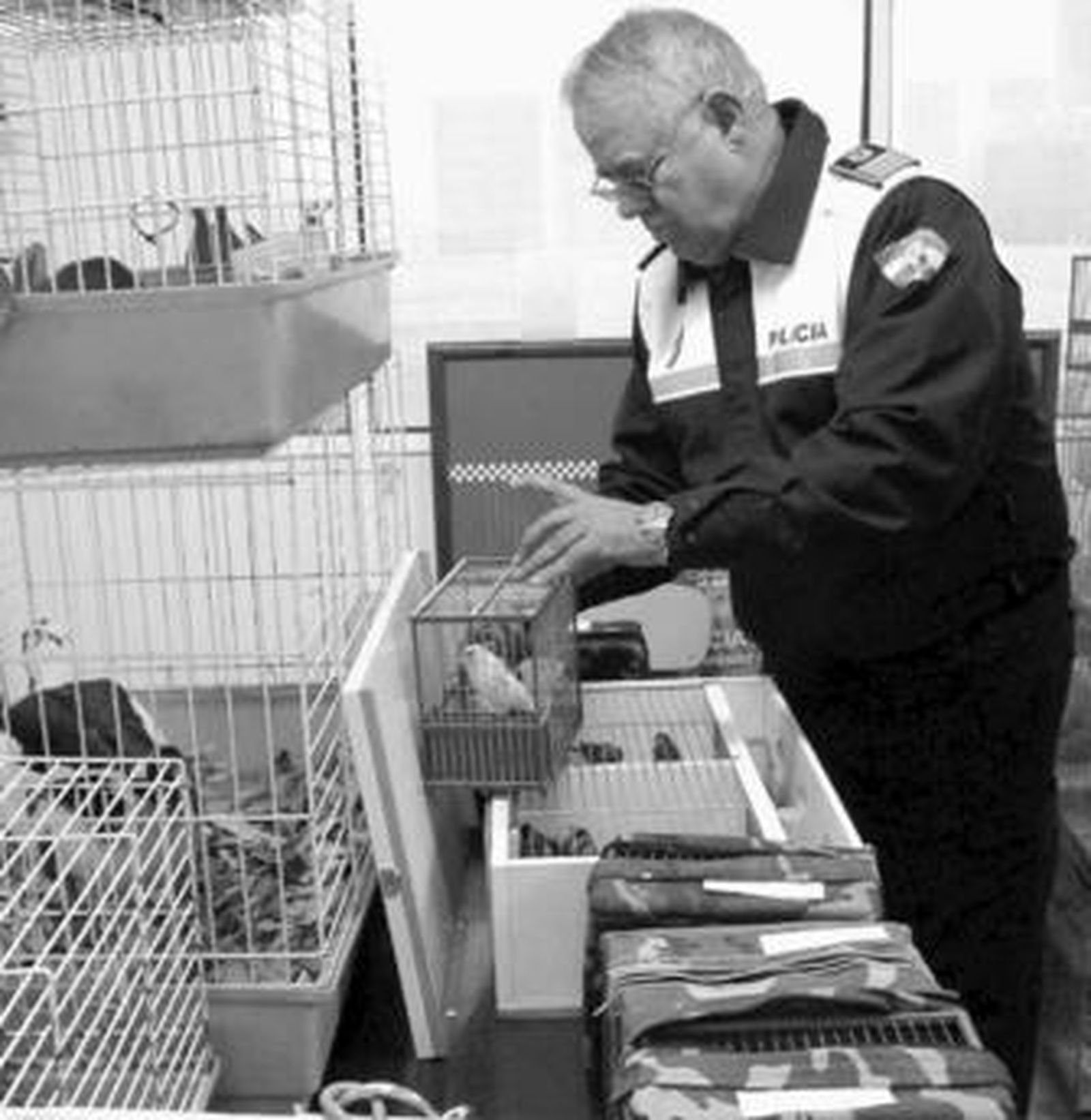 Un policía local manipula una de las jaulas intervenidas.