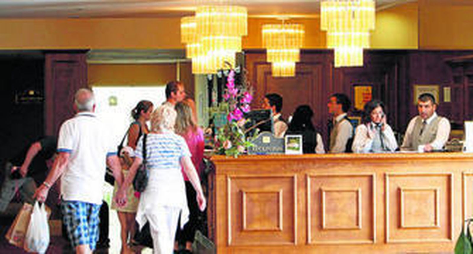 Turistas en la recepción de un hotel gaditano.