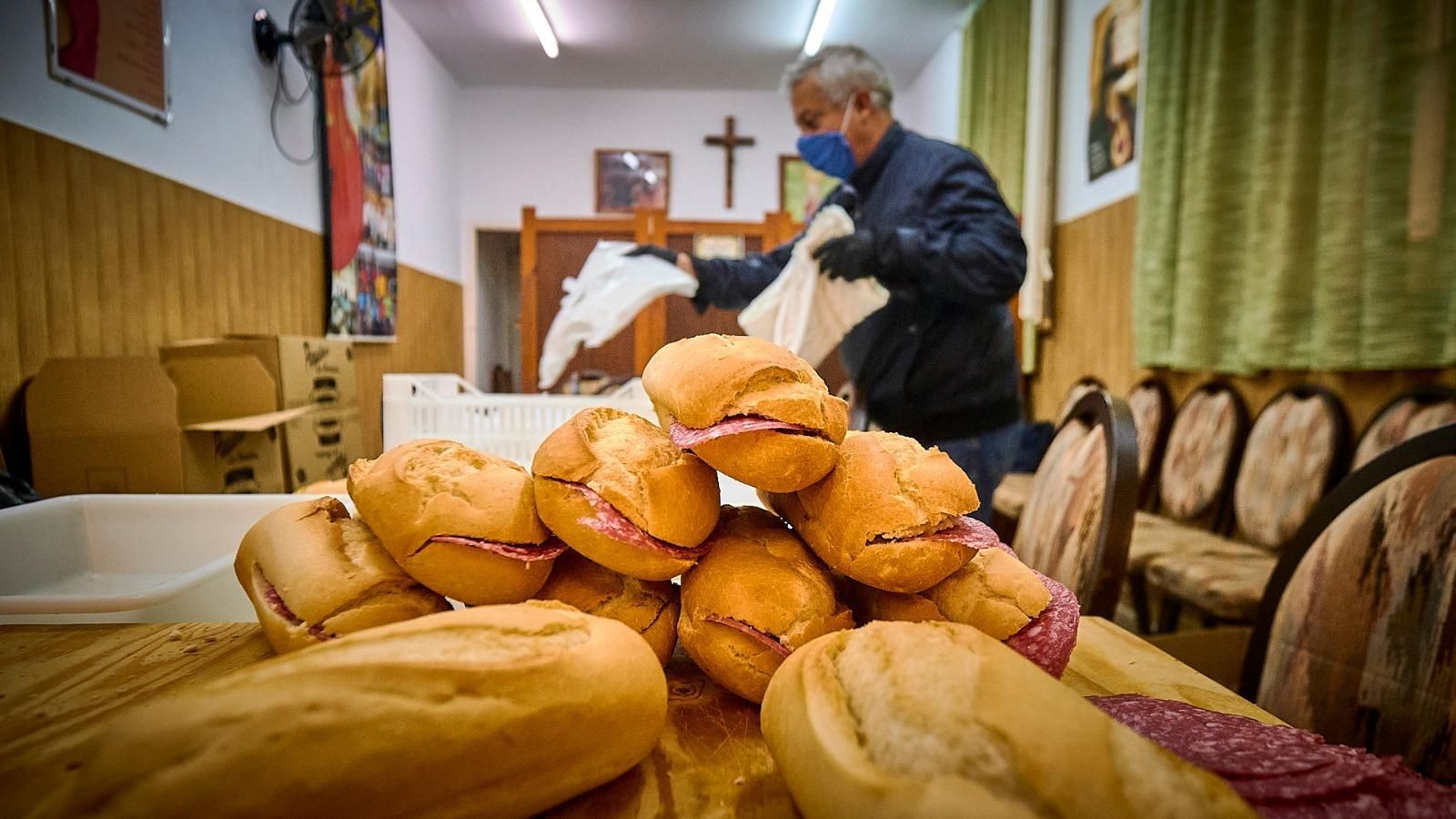 Un voluntario prepara las bolsas con bocadillos en un salón de Valvanuz.