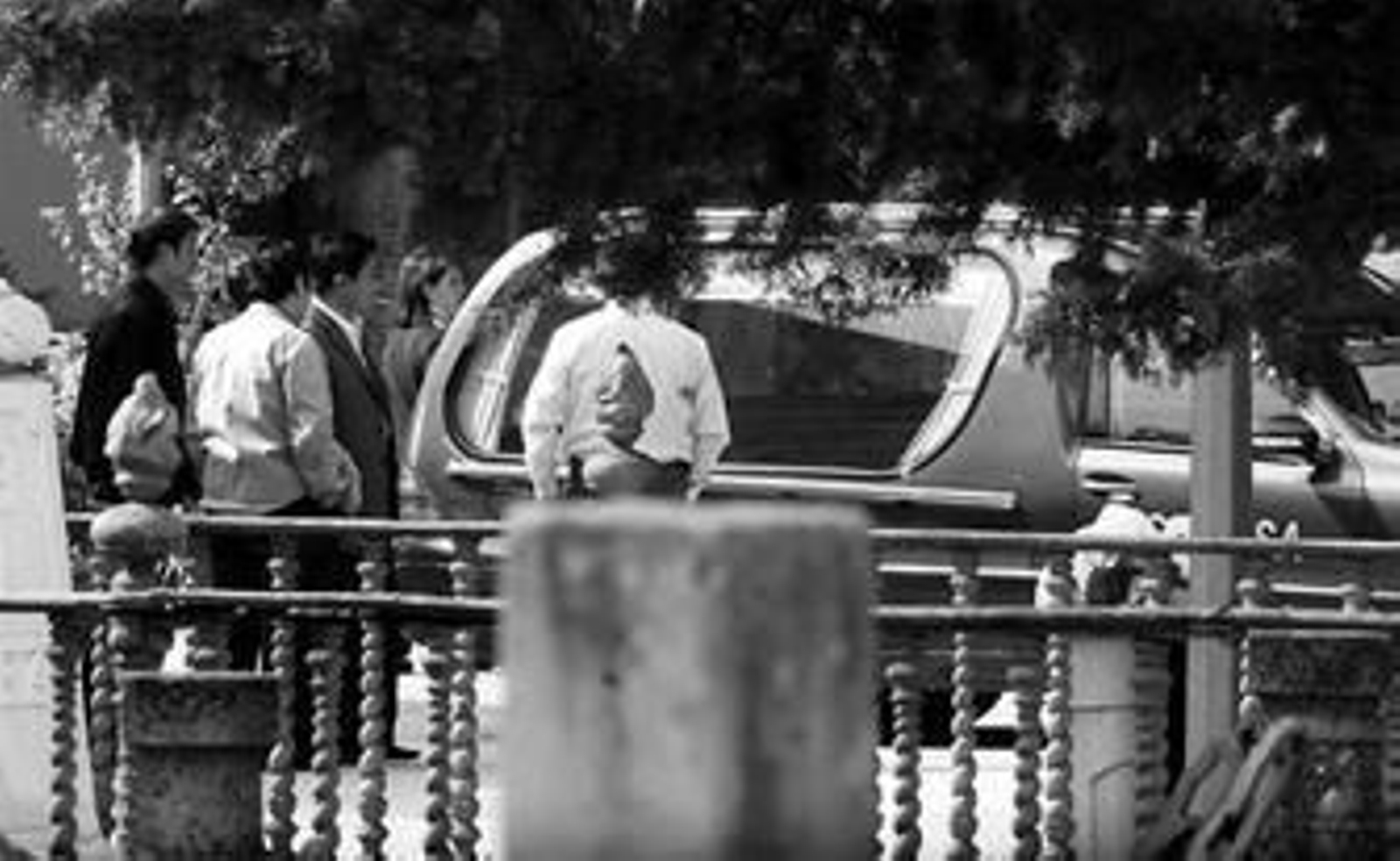 Los familiares esperan junto al coche a que el juez tome una decisión tras pedir abrir el ataúd de la fallecida.