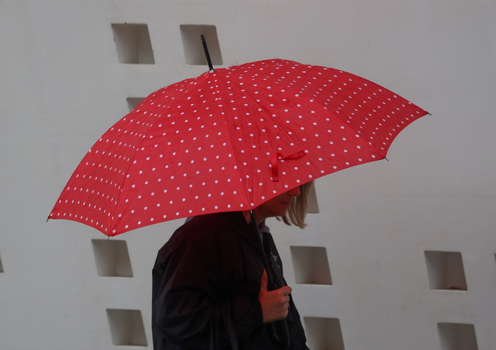 Una mujer se protege de la lluvia utilizando un paraguas.
