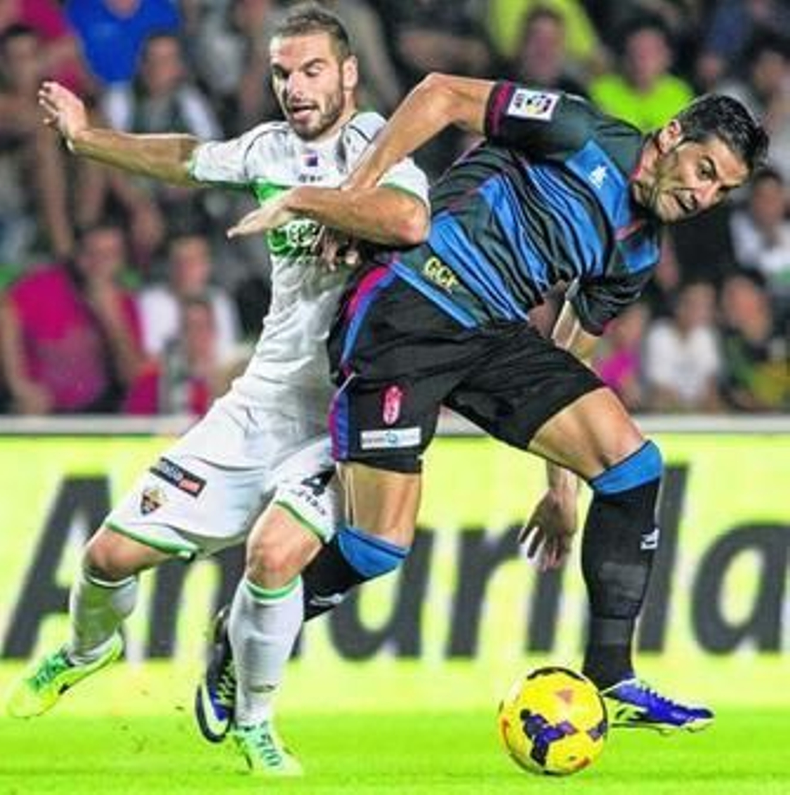 David Lombán pelea con Riki en un encuentro entre el Elche y el Granada.