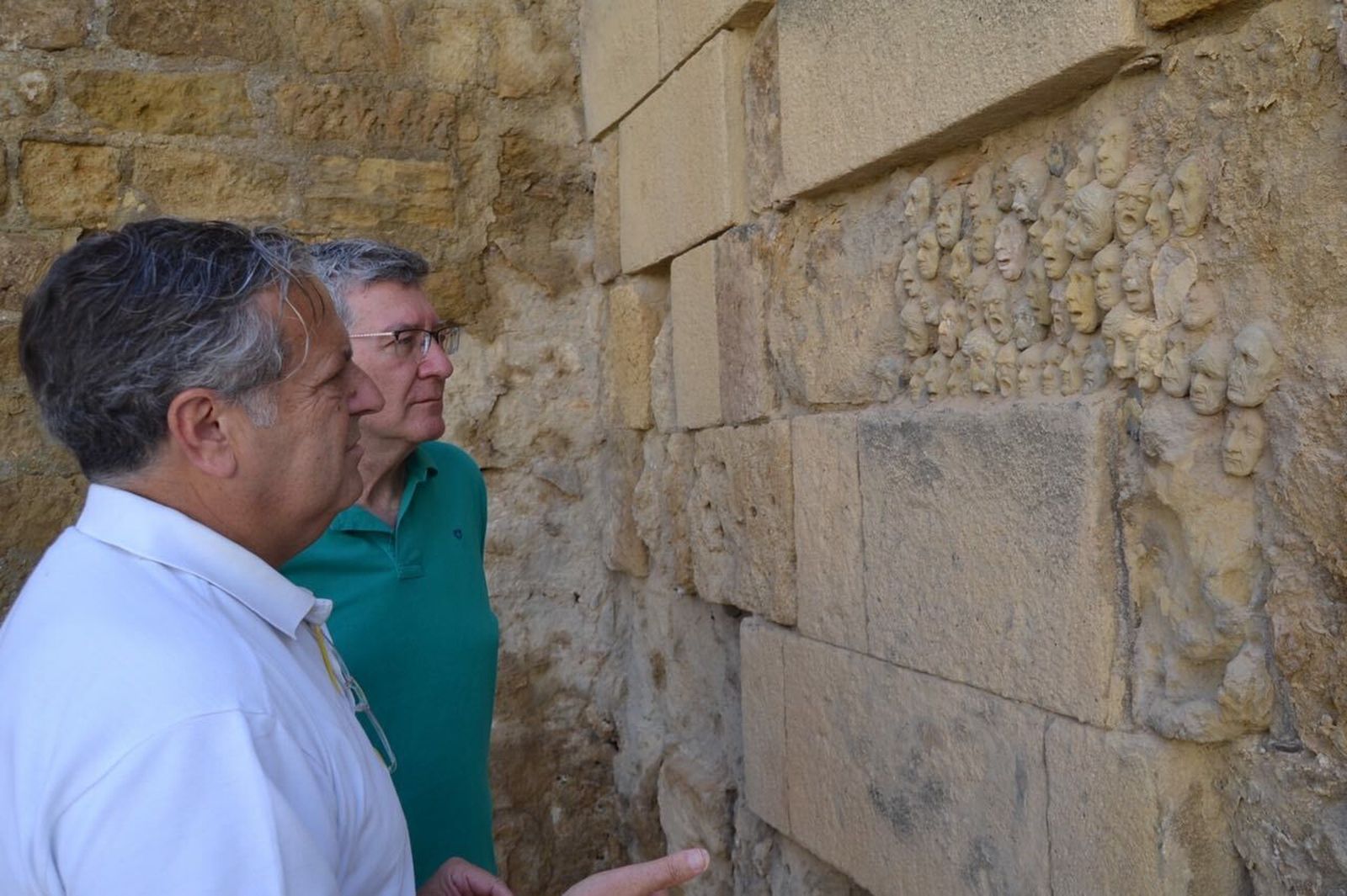 Fuentes y García observan los rostros de barros instalados en la muralla