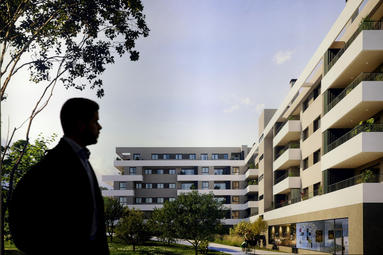 Un hombre cruza por delante de una infografía de viviendas expuesta en Simed.